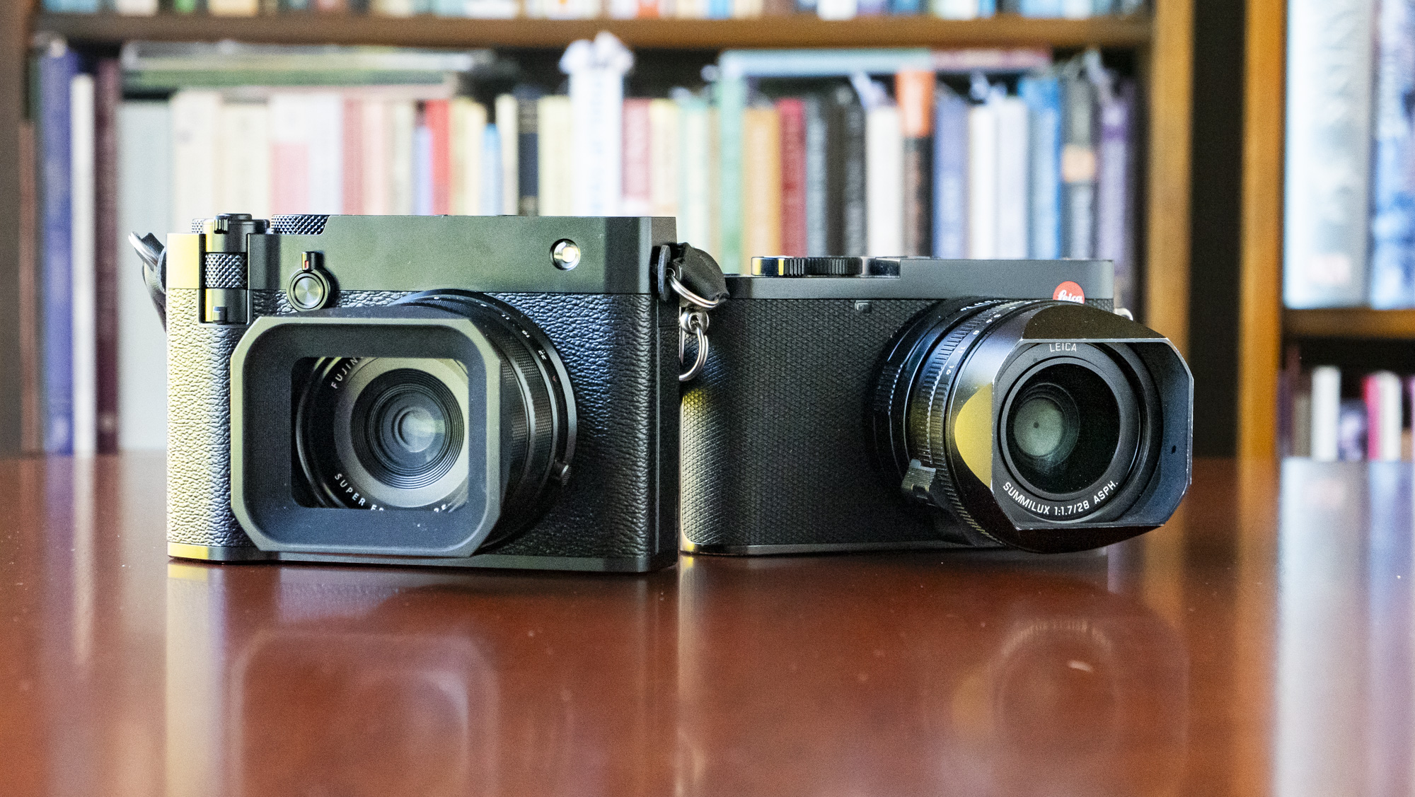Fujifilm GFX100 RF alongside Leica Q3 on a wooden table