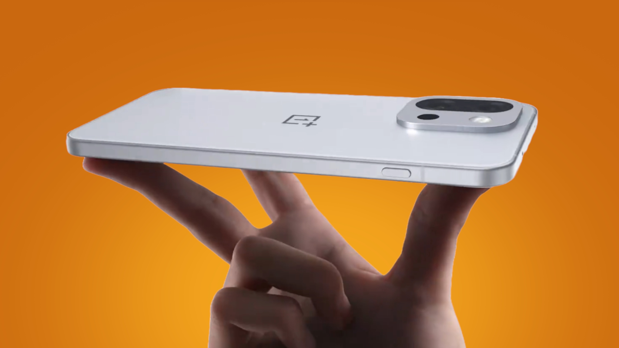 The OnePlus 13T being held in the hand on an orange background
