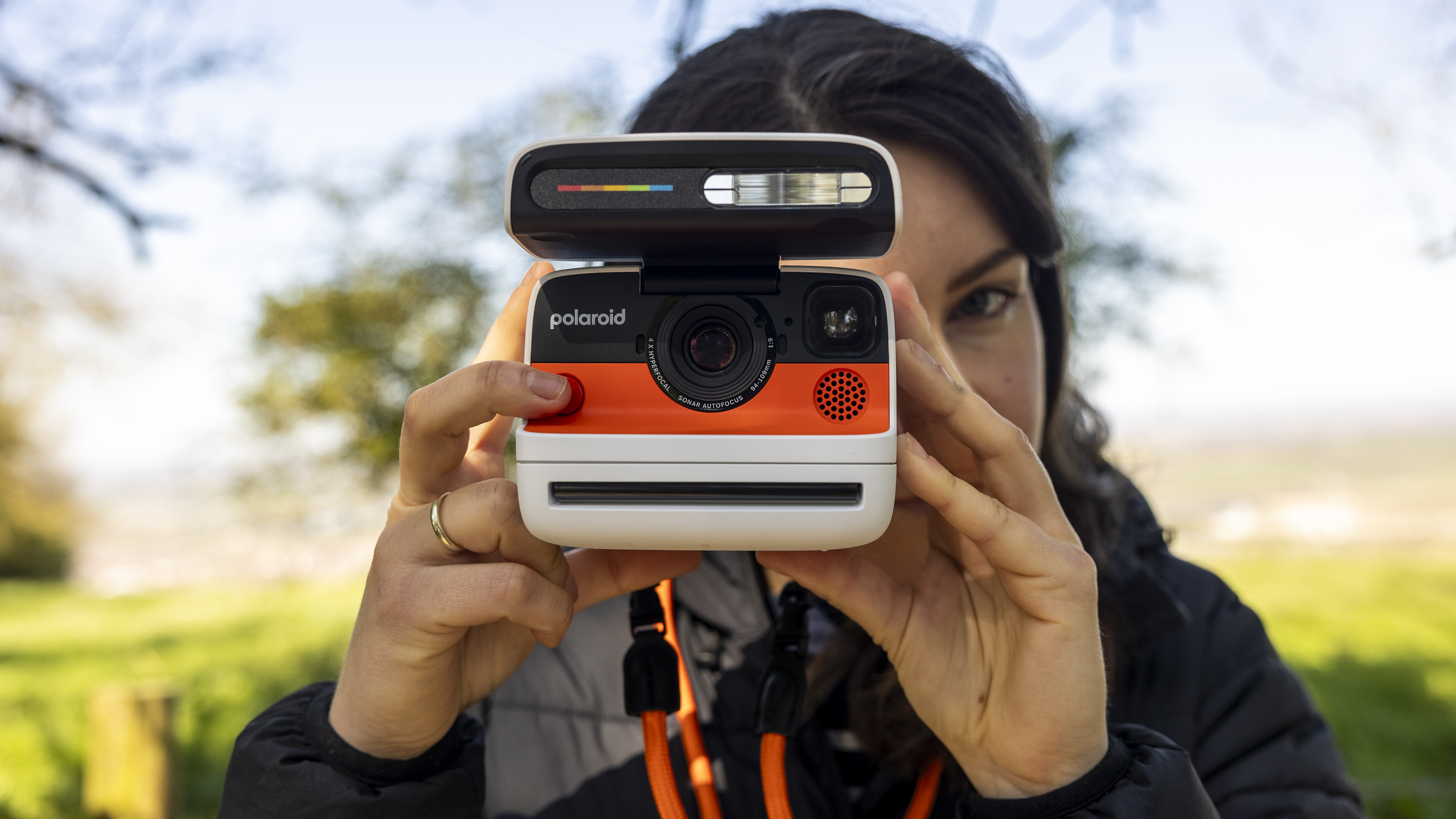 A female photographer holds the Polaroid Flip instant camera up to her face